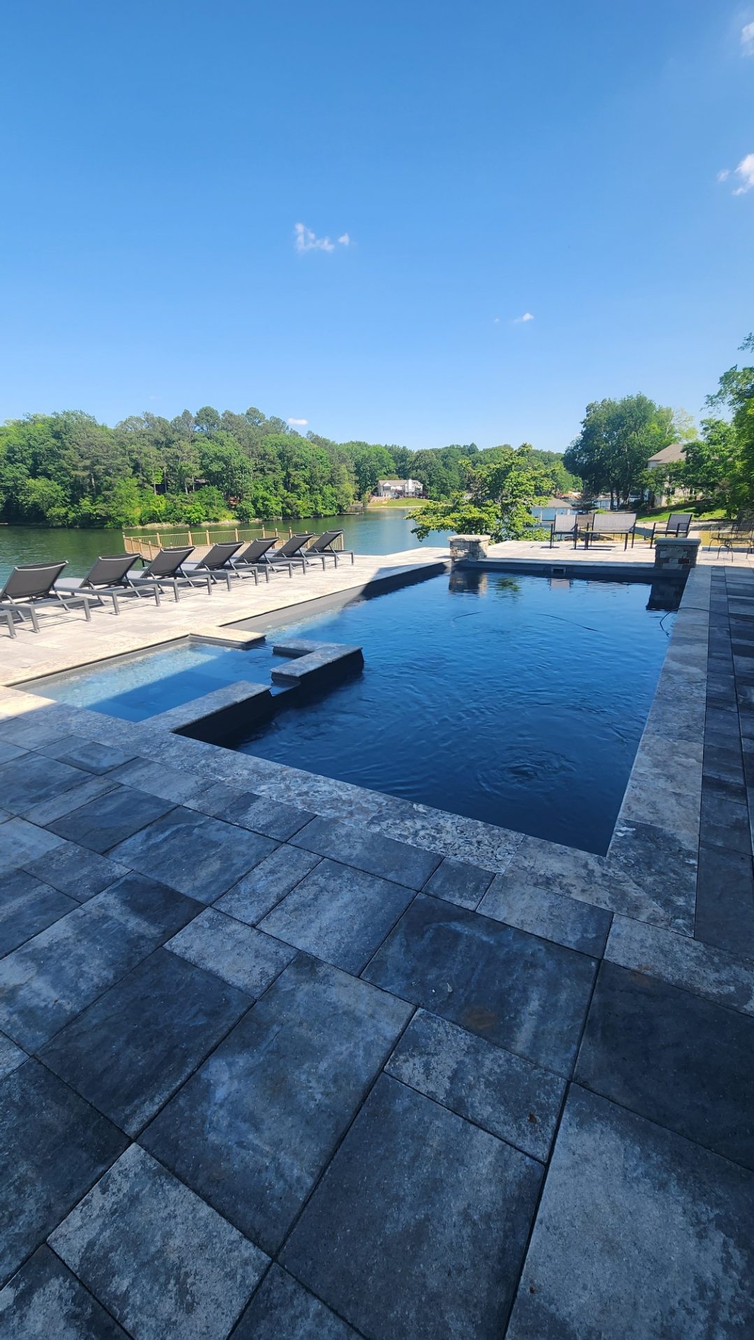 Infinity pool overlooking a serene lake.