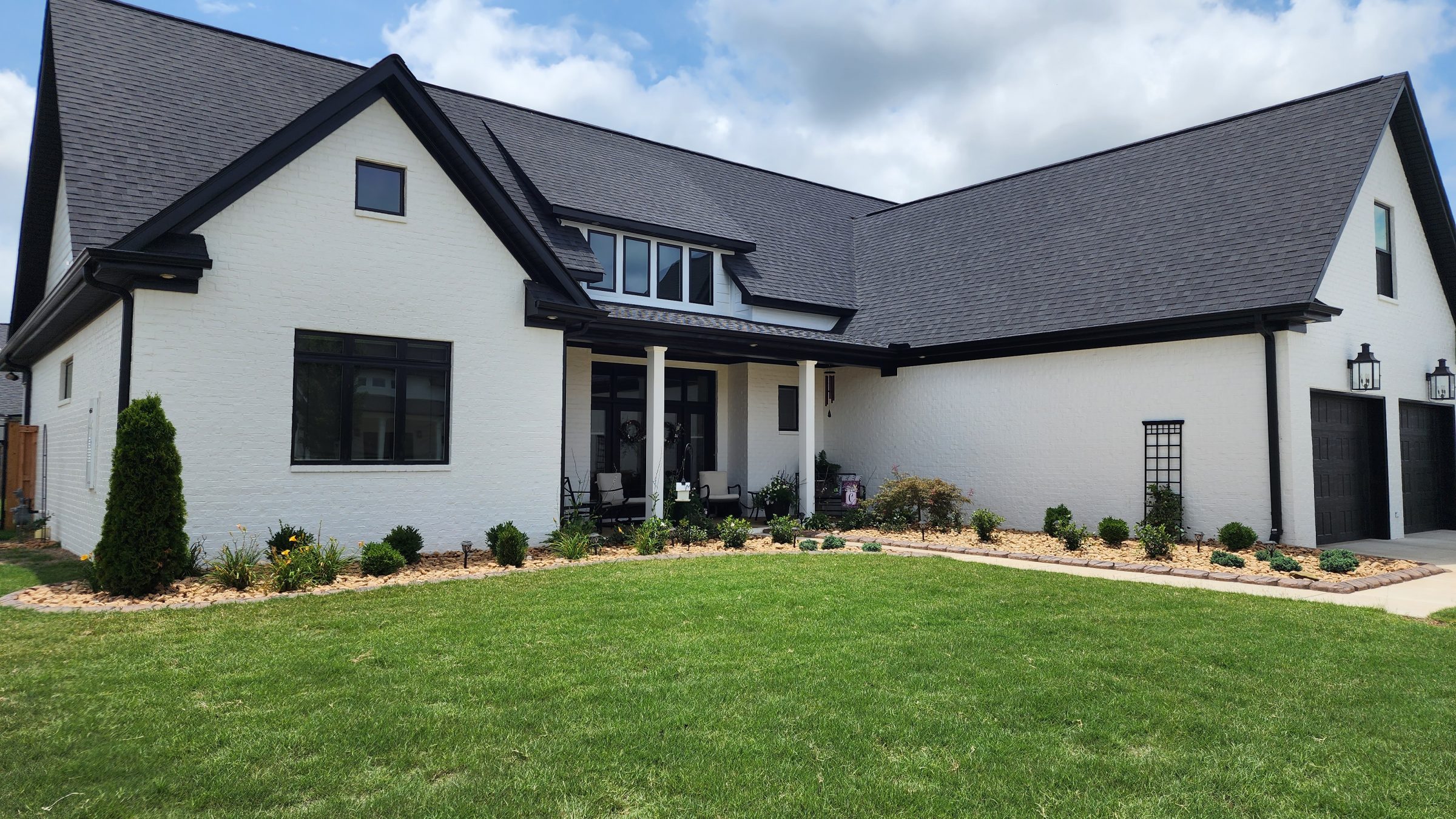 Modern white house with manicured lawn.