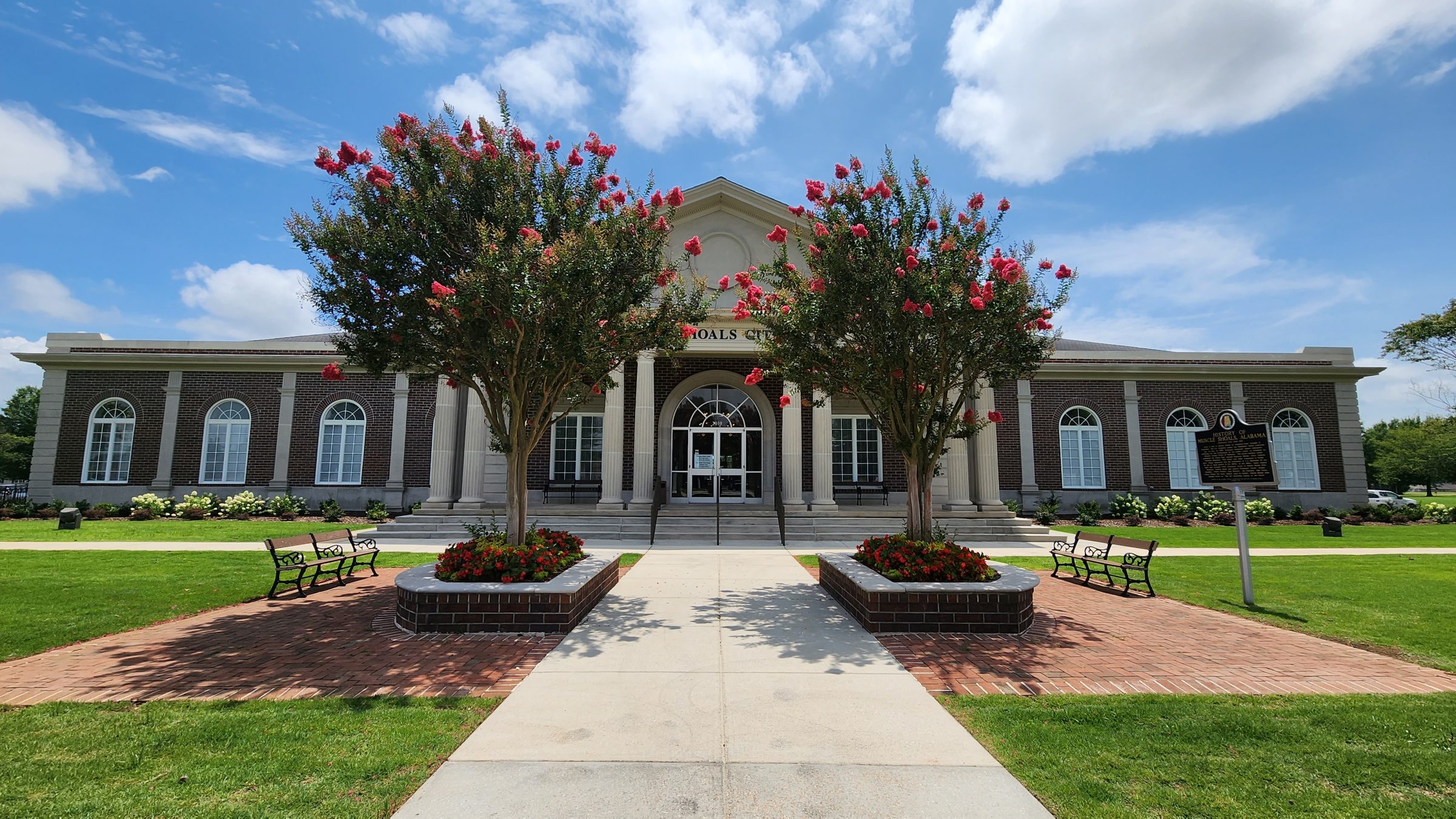 Brick building with flowering trees and benches