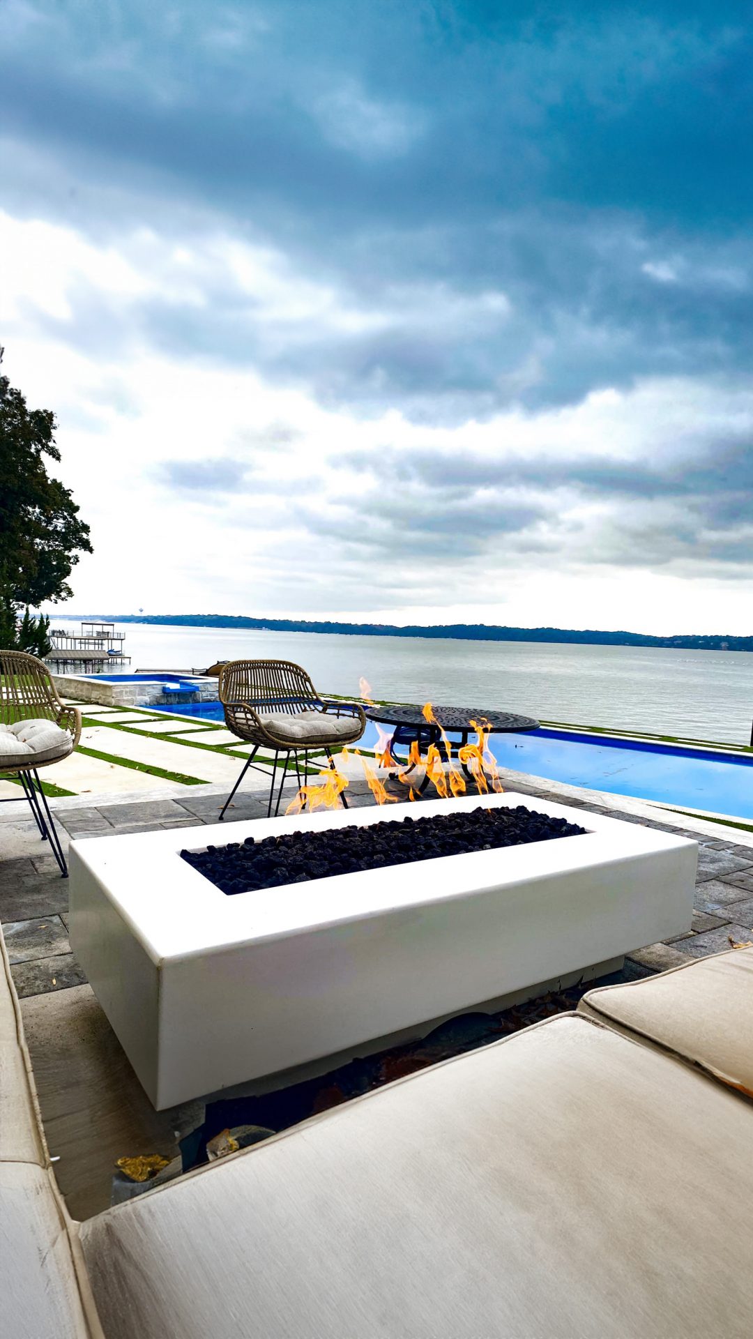 Outdoor patio with fire pit by lake