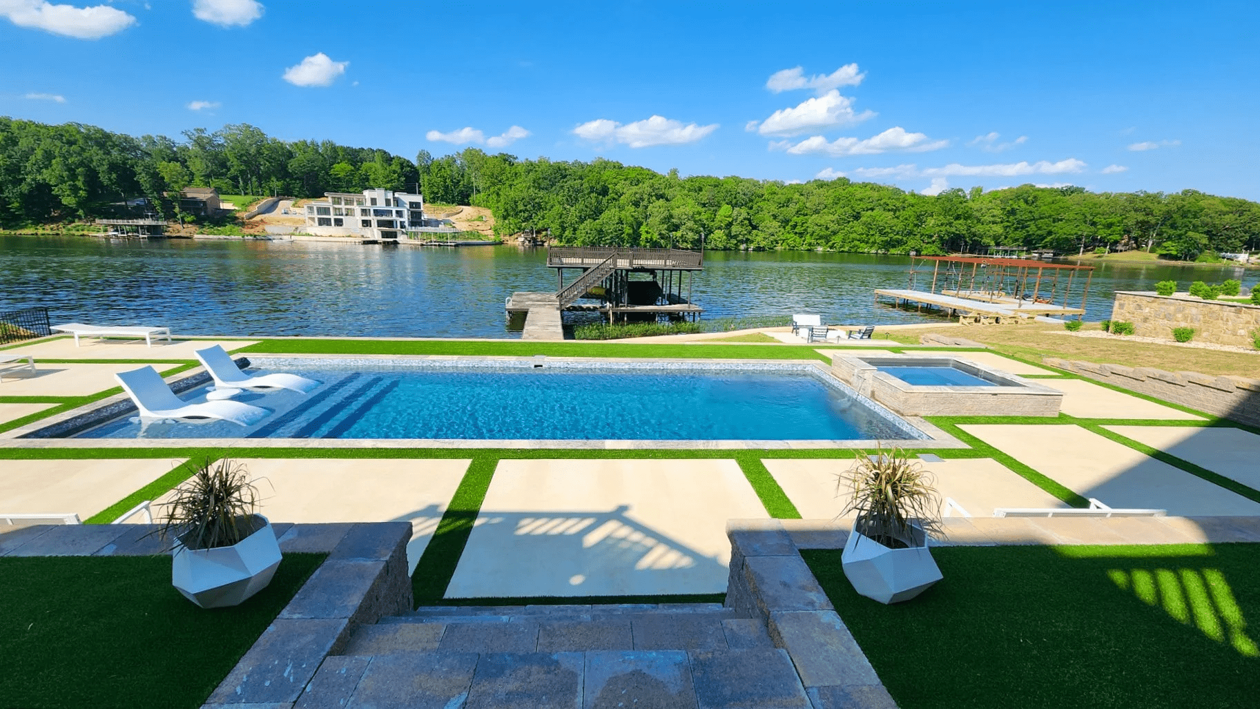 Elegant lakeside pool with deck and chairs