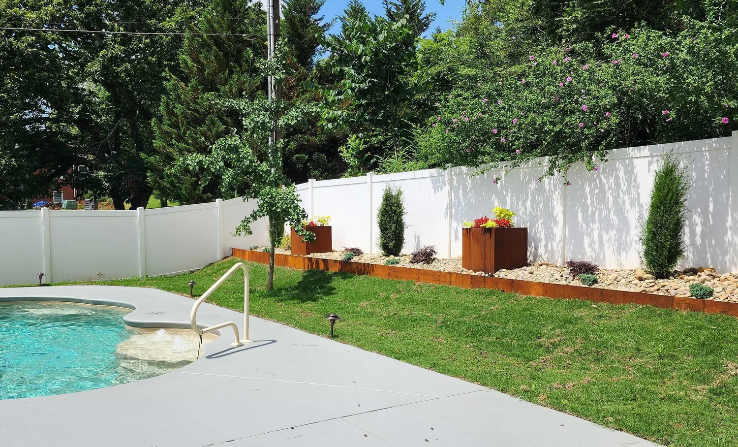 Backyard pool with garden and fence