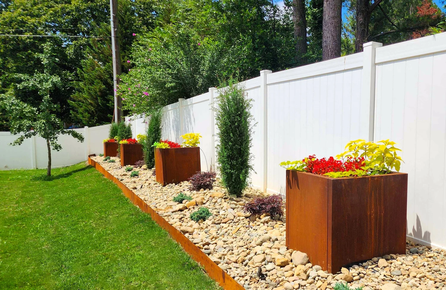 Garden with planters and white fence