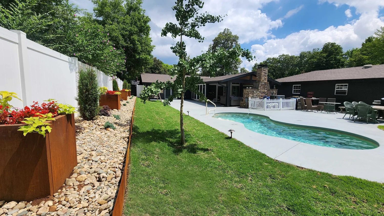 Backyard pool with garden and patio.
