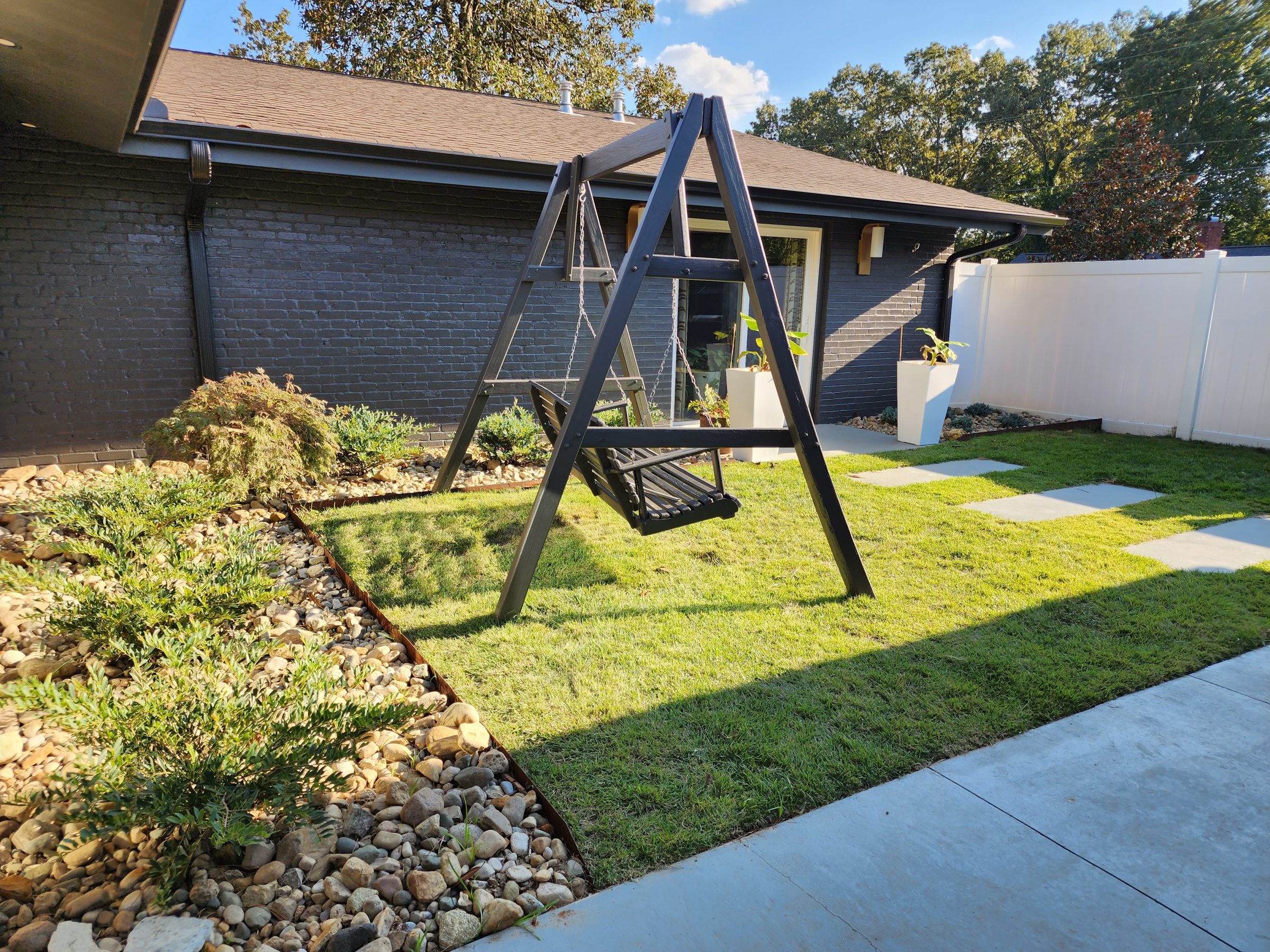 Modern backyard with swing and garden