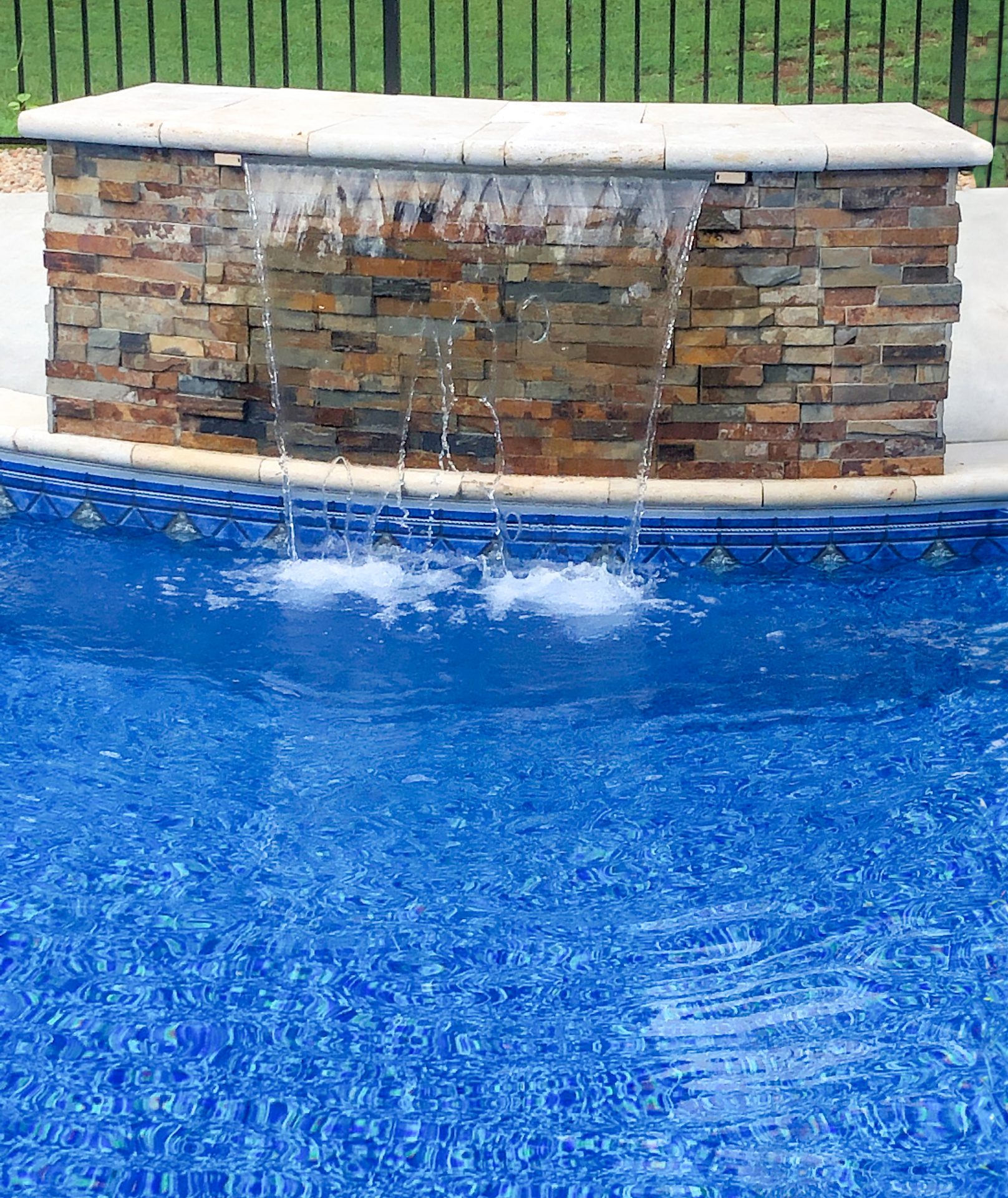 Stone waterfall into swimming pool