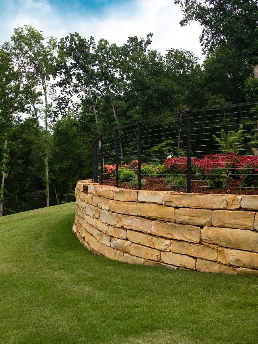 Stone retaining wall with garden on top.