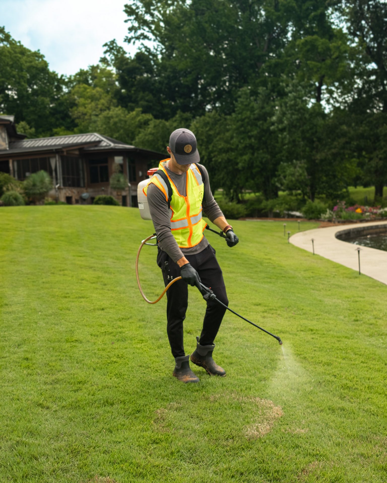 Person spraying lawn with herbicide