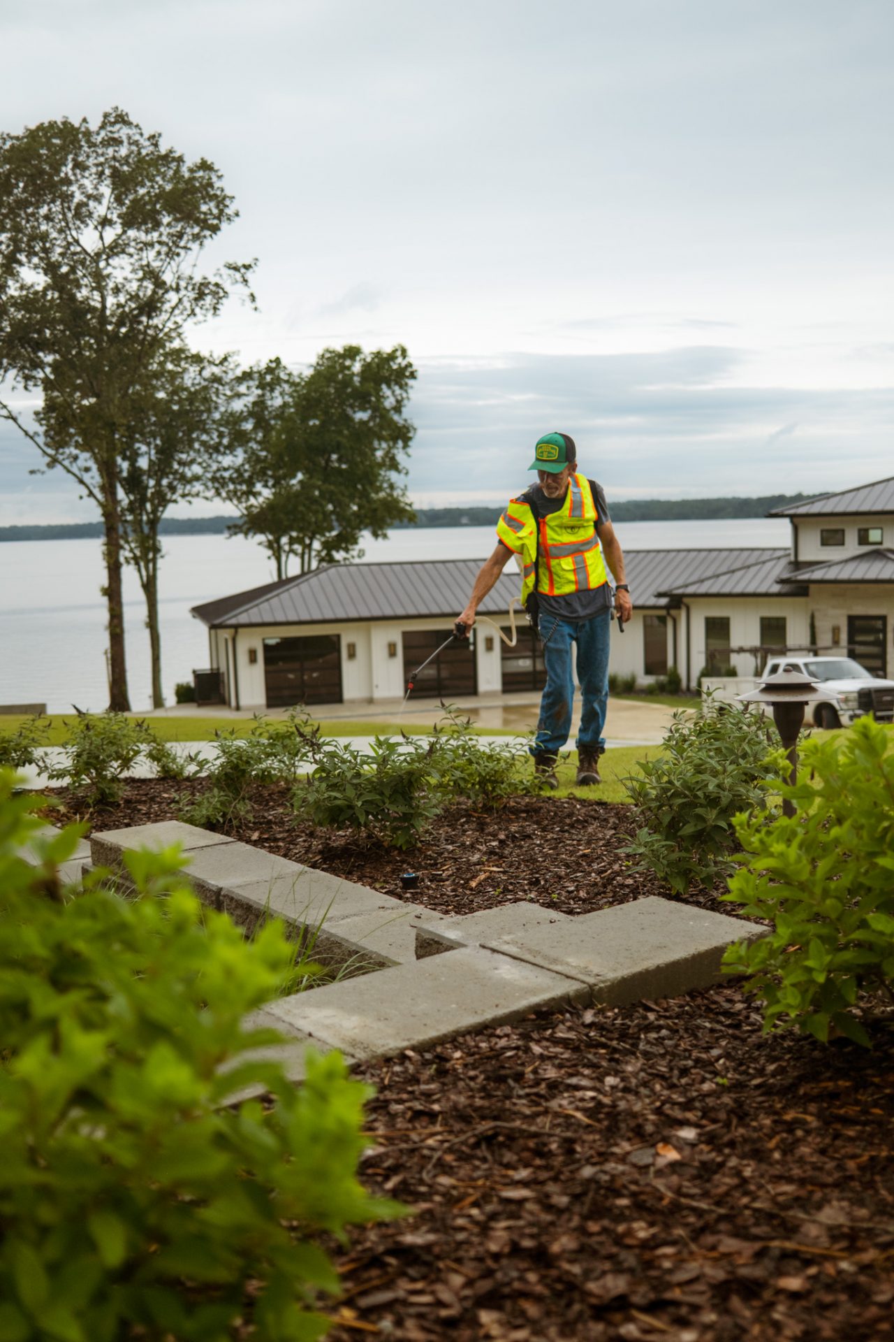 Worker in safety vest maintaining garden