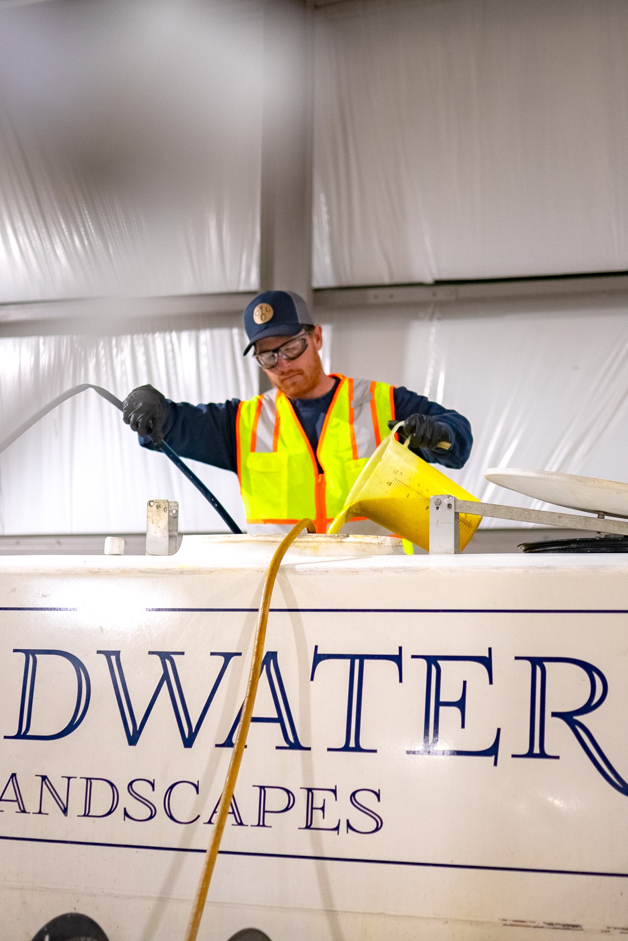 Worker pouring liquid into large container