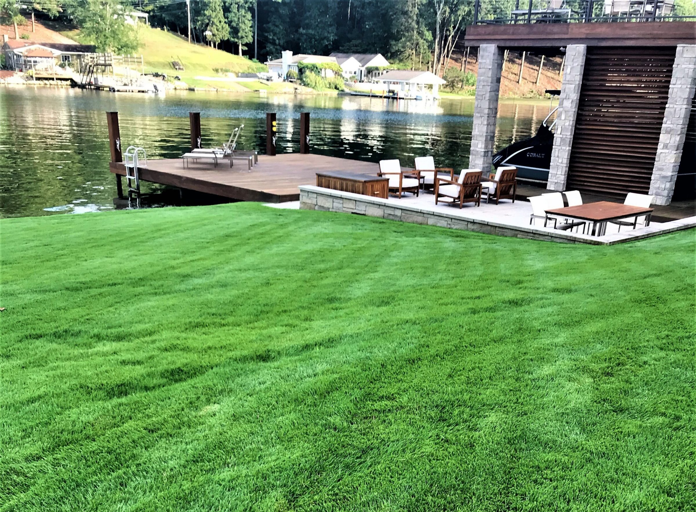 Lakeside deck with chairs and boat