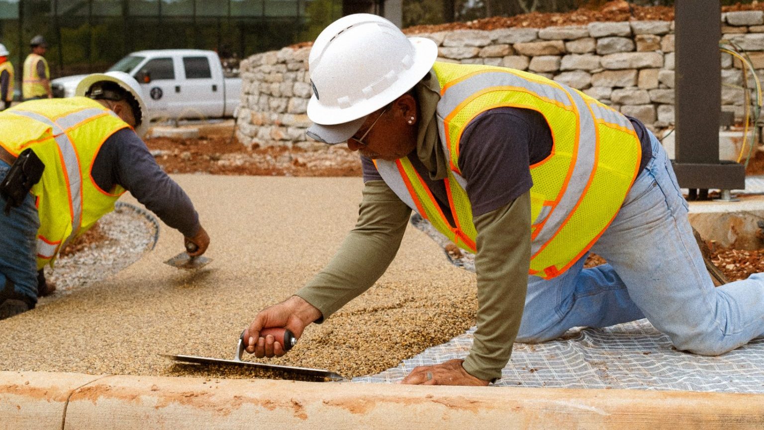 Construction workers smoothing new pavement
